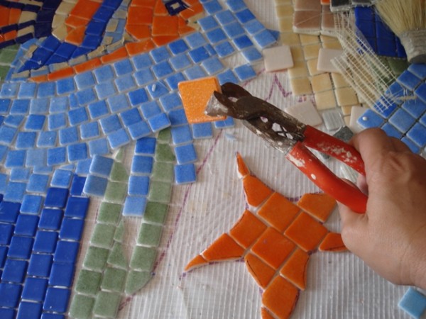 cortando azulejos de colores para mosaico
